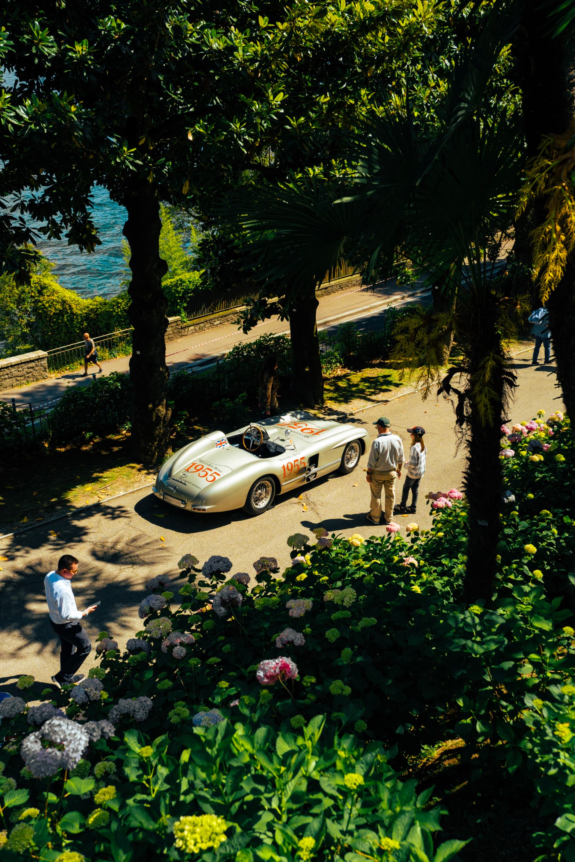 Aerial - a 1950s Mille Miglia Mercedes on the gravel path beside Lake Como