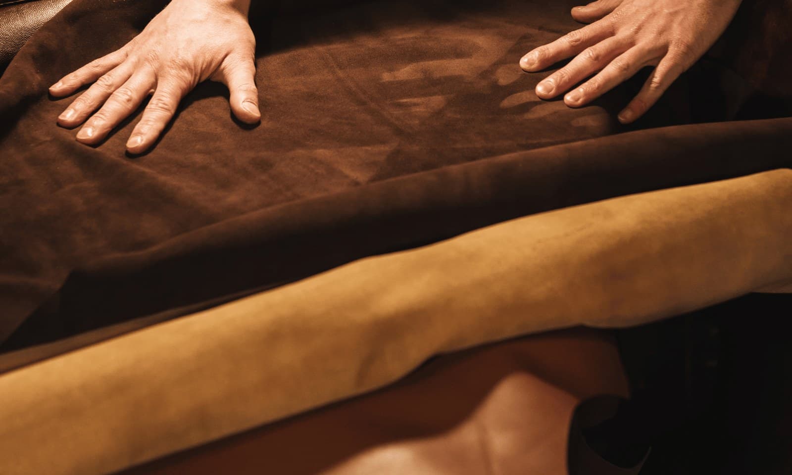 Hands on brown suede - camel leather from Al Khaznah Leathers, Abu Dhabi. The material HOF composes the season around.