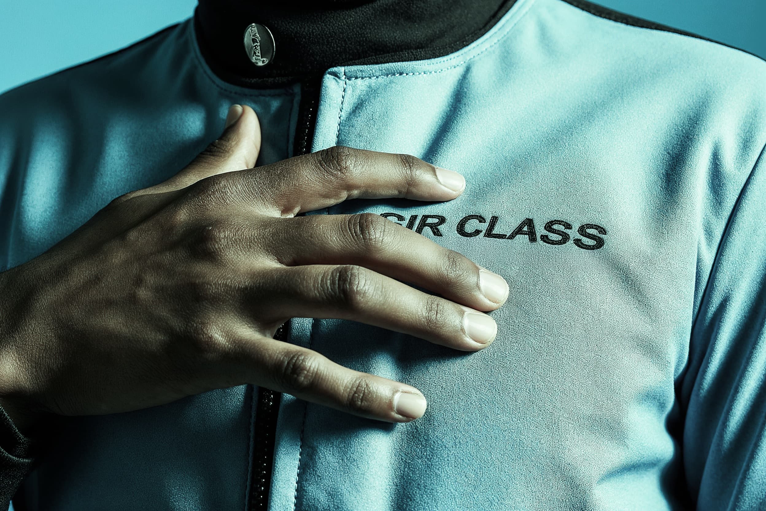 Hand-on-heart gesture on Sir Class racing suit - the tribute made physical